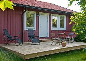 a deck with chairs and a table in front of a red house at Långänge Logi in Tandsbyn