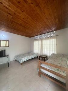 Cette chambre dispose de deux lits et d'un plafond en bois. dans l'établissement Casa vacacional con piscina privada, à Mariquita