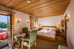 une chambre d'hôtel avec un lit, une table et des chaises dans l'établissement Landhotel Sonnleiten, à Bad Reichenhall
