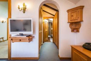 a hallway with a tv and a desk with a television at Landhotel Sonnleiten in Bad Reichenhall