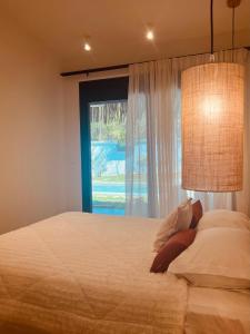 a bedroom with a large bed with a window at Naya pool & garden view bungalow in Koskinou
