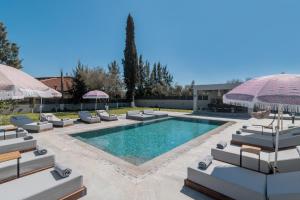 una piscina con tumbonas y sombrillas en Villa Olympia, en Pandokrátor