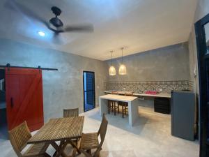 a kitchen with a table and chairs and a red door at Casa Costa Rosa - Habitación Mar in Yuluc