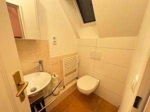 La petite salle de bains est pourvue de toilettes et d'un lavabo. dans l'établissement Cozy Wohnung in Meerbusch, à Meerbusch