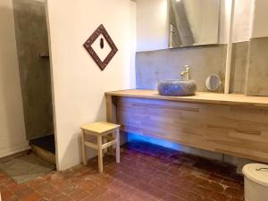 a bathroom with a sink and a mirror and a stool at Chambres et table d'hôtes Au Brabo in Mormoiron +42 photos