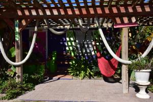 een houten pergola met hangmatten en planten bij SI COMO NO INN in Flagler Beach