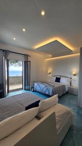a large bedroom with two beds and a large window at Villa Furoris Apartment in Furore