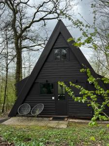 une maison noire avec deux raquettes de tennis devant elle dans l'établissement A - (frame) - Like A dream, à Durbuy