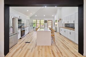 a kitchen with white cabinets and a wooden floor at Urban Farmhouse with a Modernism Twist! home in Moultrie