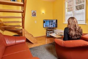 a woman sitting in a living room with a bunk bed at Ferienhaus für 4 Personen ca 55 qm in Bamberg, Bayern Franken in Bamberg