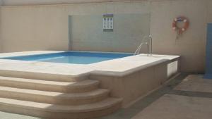 a swimming pool with stairs leading to a swimming tub at Ático en terrazas de Garrucha con vistas al mar. in Garrucha