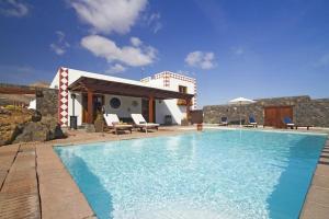 a large swimming pool in front of a house at Sehr großzügig und modern eingerichtetes Ferienhaus mit privatem Pool und Sonnenterrassen im eigenen Garten in Tías