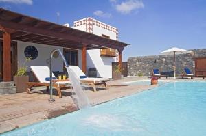einen Pool mit einem Brunnen vor einem Haus in der Unterkunft Sehr großzügig und modern eingerichtetes Ferienhaus mit privatem Pool und Sonnenterrassen im eigenen Garten in Tías