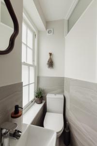 a bathroom with a toilet and a sink and a window at Holborn Townhouse in London