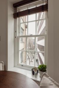 okno w pokoju ze stołem i roślinami w obiekcie Holborn Townhouse w Londynie