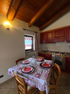 uma cozinha com uma mesa com pratos vermelhos em BAITA ARIANNA - BILOCALE MOTTA em Sestriere