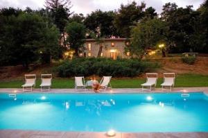 un gruppo di sedie intorno alla piscina di Ferienhaus mit Privatpool für 2 Personen ca 70 qm in Poppi, Toskana Provinz Arezzo a Poppi
