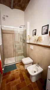 y baño con ducha, aseo y lavamanos. en Casa ROMA21, en Buonconvento