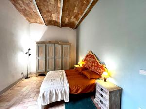 1 dormitorio con cama y techo de madera en Casa ROMA21, en Buonconvento