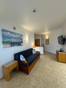 a living room with a couch and a picture of a bus at Sofiamarholidays - Casa Praia Mar in Portimão