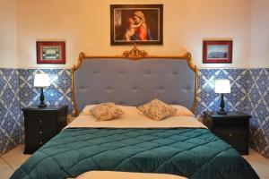 a bedroom with a blue bed with two lamps at Todisco Apartament in Pompei