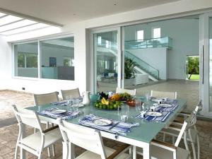 comedor con mesa azul y sillas blancas en Villa con piscina en frente al mar con servicios en San Carlos