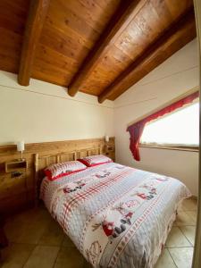 um quarto com uma cama num quarto com tectos em madeira em BAITA ARIANNA - BILOCALE MOTTA em Sestriere