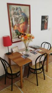 stół jadalny z wazonem kwiatów w obiekcie Trionfal Apartment w Rzymie