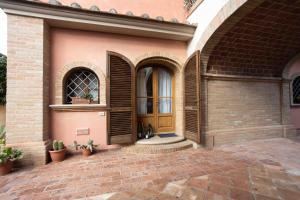 Cette maison dispose d'une porte en bois et d'une terrasse en briques. dans l'établissement CASA FLORA, à Rivoli