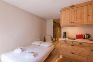 a bedroom with a bed and a dresser at Cosy apartment near the slopes in Megève - Welkeys in Megève