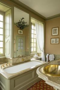 a large bathroom with a large tub and a sink at Chateau De Pont-Rilly in Négreville