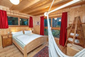 1 dormitorio con hamaca en una cabaña de madera en Chalet PINO, en Tret