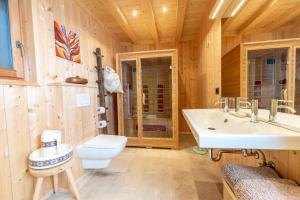a bathroom with a white sink and a toilet at Chalet PINO in Tret