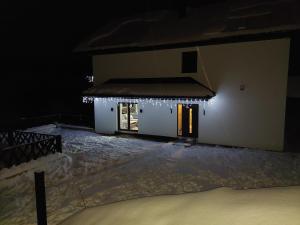 a house with christmas lights on it at night at Apartamenty TRIO in Muszyna