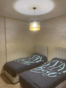 twee bedden in een slaapkamer met een licht en een lamp bij Agadir Bay in Agadir