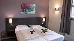 2 camas en una habitación de hotel con toallas blancas en Modern eingerichteter Bungalow - b56111, en Oostrum