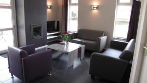Sala de estar con sofás y mesa de centro en Modern eingerichteter Bungalow - b56111, en Oostrum