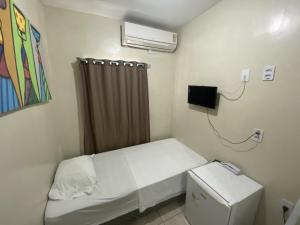 een kleine kamer met een klein bed en verwarming bij Hotel Pousada dos Anjos in João Pessoa