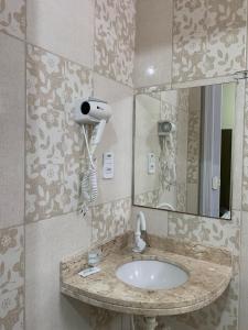 a bathroom with a sink and a mirror at Hotel Pousada dos Anjos in João Pessoa