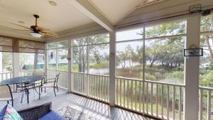 a screened porch with a table and chairs at Litchfield Lakeside Oasis 2BR Villa near the Beach in Pawleys Island