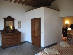 een slaapkamer met een bed, een dressoir en een spiegel bij Ferienwohnung in Barberino Tavarnelle mit Privatem Garten - b58103 in San Donato in Poggio