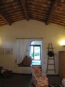 een woonkamer met een ladder, een stoel en een raam bij Ferienwohnung in Barberino Tavarnelle mit Privatem Garten - b58103 in San Donato in Poggio