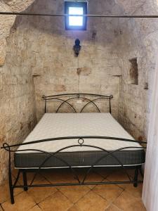 - une chambre avec un lit dans un mur en pierre dans l'établissement Trullo LuCe Ostuni, à Ostuni