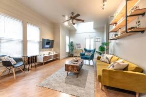 uma sala de estar com um sofá amarelo e uma mesa em New Gathering Place on Columbus em Waco
