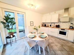a kitchen with a table and chairs in a kitchen at Spacious one bedroom with garden&balcony in Pulvermühle