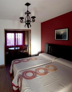 a bedroom with a large bed with a red wall at Ferienhaus in Gálvez mit Offenem Kamin in Gálvez