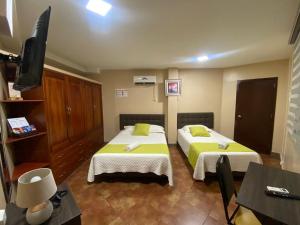 a hotel room with two beds and a television at YORMARI HOTEL in Manta