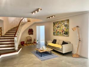 uma sala de estar com um sofá e uma escada em Hostal Casa Mosaiko Nutibara Laureles em Medellín