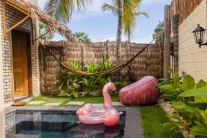 two pink flamingos in a backyard with a hammock at Villa Malie in Santo Amaro