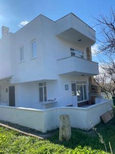 a large white house with at Bozcaada Manzaralı Müstakil Bahçeli Aileye Uygun Villa in Canakkale